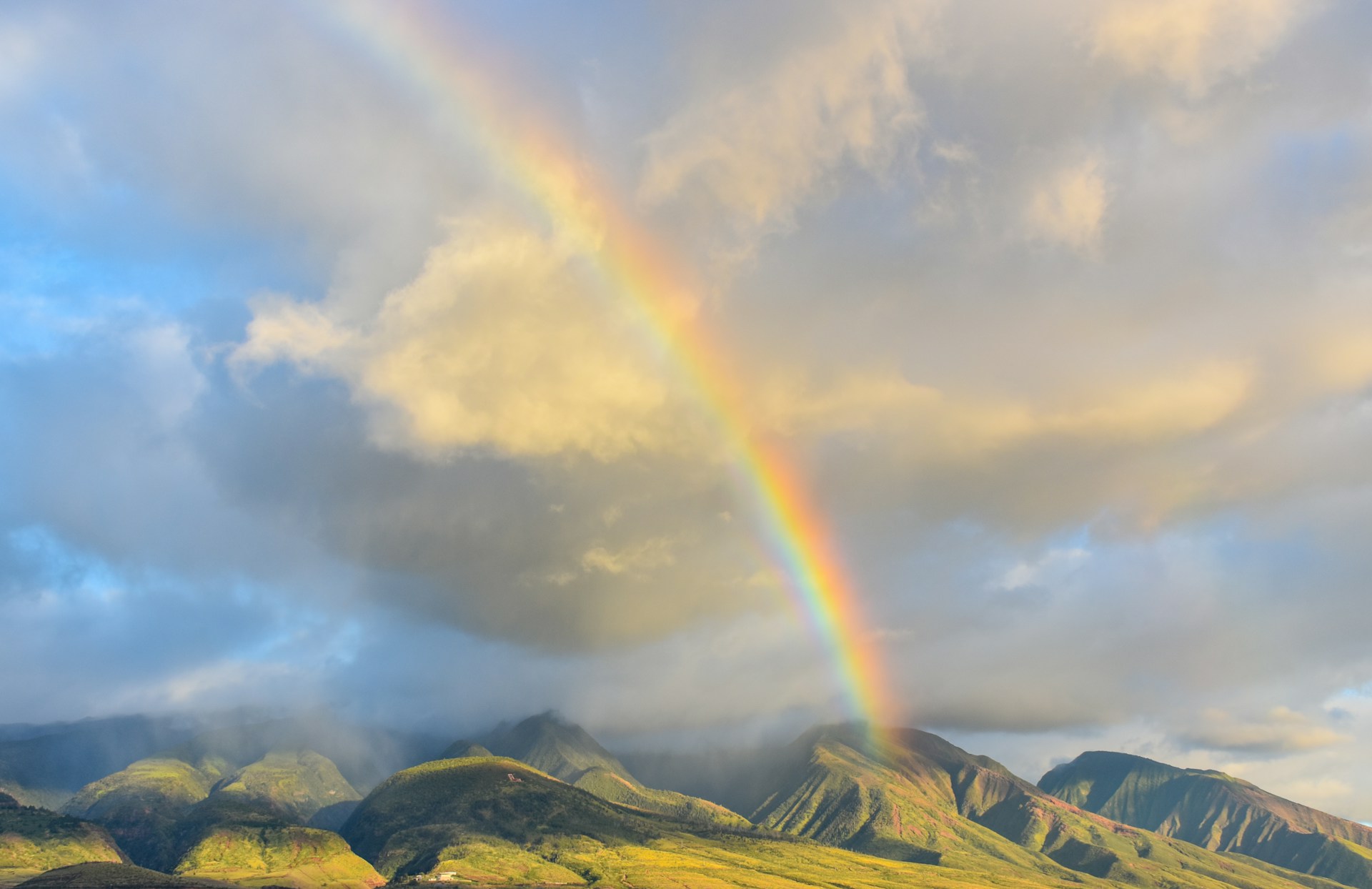 rainbow over grassy hills